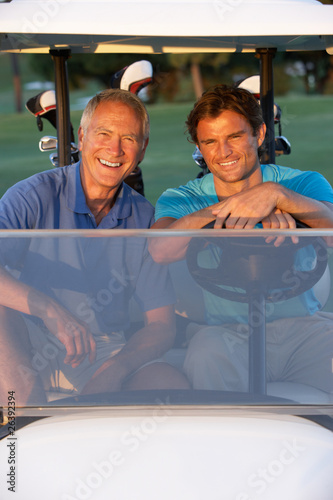 Photo: Two Male Golfers Riding In Golf Buggy On Golf Course Two Male Golfers Riding In Golf Buggy On Golf Course