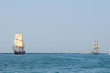 Two tall sailing ships, one being pursued by the other