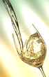 Pour white vine into glass with light background. Pour white vine into glass with light background.