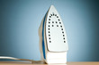 Modern electric iron against the colorful background Modern electric iron against the colorful background