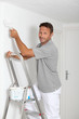 Man painting walls in white
