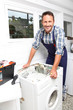 Plumber fixing broken washing machine