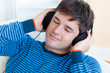 peaceful man listening music holding his earphones lying on the