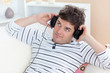 thoughful man listening music looking the top sitting in the sof
