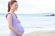 Young pretty pregnant woman standing on the beach Young pretty pregnant woman standing on the beach