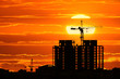 Construction project silhouette against sunset sky with big sun Construction project silhouette against sunset sky with big sun