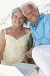 Happy Senior Couple using Laptop Computer on a Beach