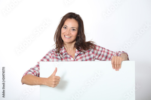 Photo: Woman showing white board on white background Woman showing white board on white background