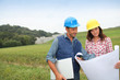 Business people checking plan on construction site Business people checking plan on construction site