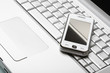 Modern communications concept. White communicator on silver lapt Modern communications concept. White communicator on silver lapt