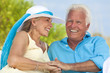 Happy Senior Couple Holding Hands & Laughing at the Beach