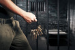 prison guard with keys walking outside dark prison cell