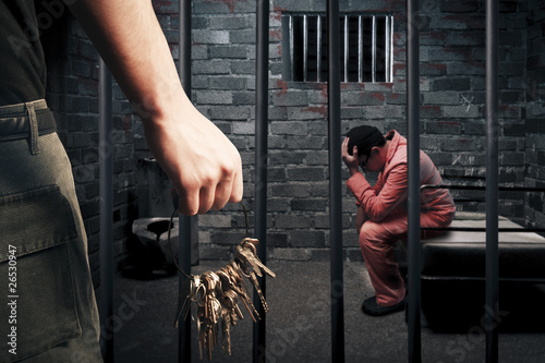 Photo: prison guard with keys outside dark prison cell prison guard with keys outside dark prison cell
