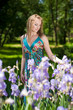 A beautiful model stays amid tall lilac flowers