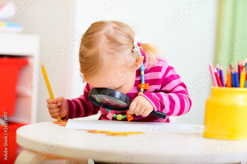 Photo: Toddler girl looking through magnifier Toddler girl looking through magnifier