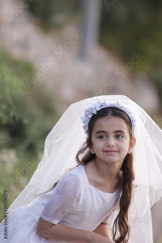 Photo: Young girl outside in a holy communion dress Young girl outside in a holy communion dress