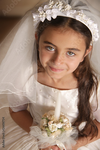 Photo: Girl in holy communion dress and veil, holding a candle Girl in holy communion dress and veil, holding a candle