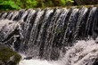 Waterfall close up. Water cascade on moss stones