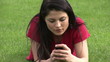 Captivating woman using cellphone lying on the grass