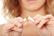 Young woman breaking cigarette