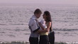 Young couple on the beach looking after their baby