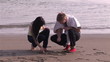 Lovely couple writing love message on the sand during honeymoon