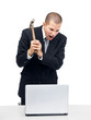 Furious businessman destroying his laptop with a hammer Furious businessman destroying his laptop with a hammer