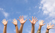 Hands rised up in air across  sky