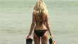 Woman with flippers on the beach turning and looking the camera