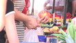 Close up of a customer putting apples in a plastic bag