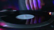 Zoom in and out of a dj mixing a disk at a party