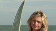Video: Portrait of a female surfer on the beach with her surfboard Portrait of a female surfer on the beach with her surfboard
