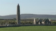 Footage showing a ruined church and tombs in a green landscape
