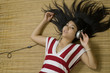 Asian woman laying down listening to music