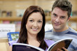 Portrait of a cute couple reading a book in a shop Portrait of a cute couple reading a book in a shop