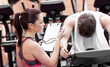 Female coach using a chronometer while man is on bicycle