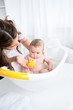 Beautiful mother giving the bath to her baby Beautiful mother giving the bath to her baby