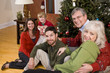 Photo: Family holiday gathering by Christmas tree Family holiday gathering by Christmas tree