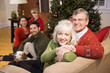 Photo: Senior couple with family by Christmas tree Senior couple with family by Christmas tree