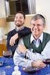 Senior Jewish man, adult son celebrating Hanukkah