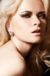 Luxury woman model with diamond earrings and blond hair