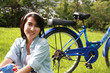 Woman with a bike outdoors smiling Woman with a bike outdoors smiling