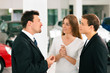 Couple with salesman at car dealer