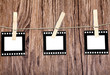 old film blanks hanging on a rope held by clothespins over wood