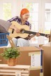 Smiling woman with guitar at moving
