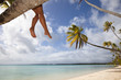 Women's legs on white sand beach