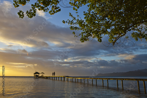 Photo: Couple walk on pontoon at sunset Couple walk on pontoon at sunset