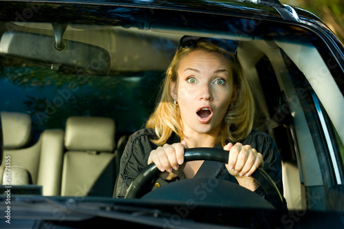 Photo: Fright face of woman driving car - inside Fright face of woman driving car - inside