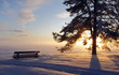 Emty park bench covered with snow in sunset Emty park bench covered with snow in sunset