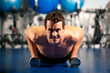 Mann macht Liegestütze im Fitnessstudio